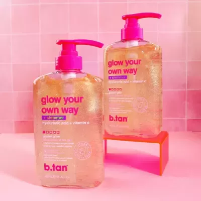 Frascos de gel autobronzeador dourado com tampa rosa em fundo rosa azulejado