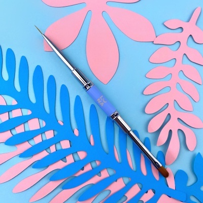 Pincel de maquilhagem com cabo azul e metálico sobre folhas de papel azuis e rosas