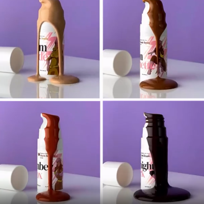 Frascos brancos cobertos com líquidos castanhos de vários tons sobre superfície branca refletora e fundo roxo.