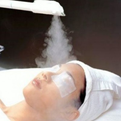 Pessoa a receber tratamento facial com vapor e compressa nos olhos