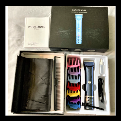 Kit de barbeiro com máquina azul e preto, pentes coloridos, óleo, cabo USB e acessórios numa caixa preta.