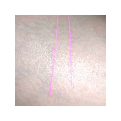 Pele clara com linhas rosa fluorescentes desenhadas em paralelo