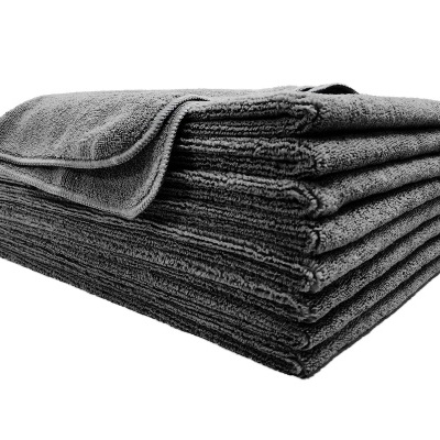 Toalha cinza escura de algodão dobrada com textura felpuda