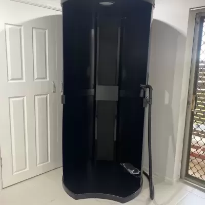 Cabine de vestir preta com vaporizador de roupa num ambiente interior