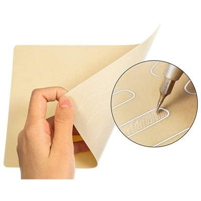 Folha fina bege com padrão branco e ferramenta desenhando detalhe branco na folha