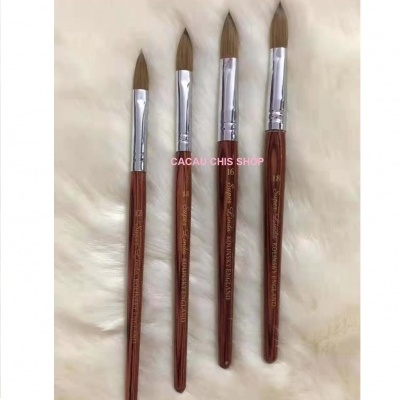 Quatro pincéis de pintura com cabos castanhos sobre tecido branco peludo