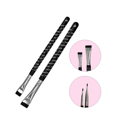Duas escovas de maquilhagem com cabo preto e detalhes em branco, apresentadas em close-up sobre fundo branco e círculos cor-de-rosa