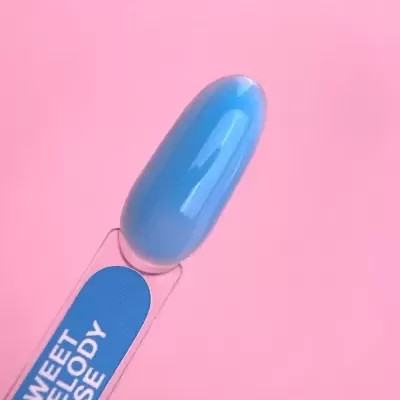 Amostra de verniz de unhas azul brilhante com rótulo em fundo rosa