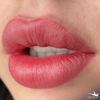 Lábios com batom vermelho rosado em close-up