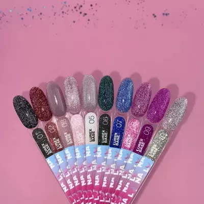 Amostras de verniz glitter em várias cores dispostas em leque sobre fundo rosa