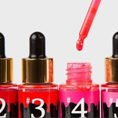Frascos numerados 2 a 5 de verniz para unhas vermelhos e rosa com tampas de conta-gotas.