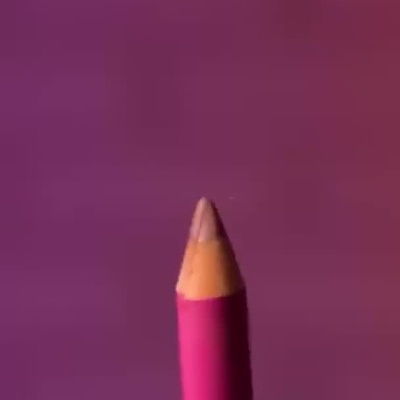 Apontador e lápis de lábios da marca ZOLA sendo usados com luvas pretas.