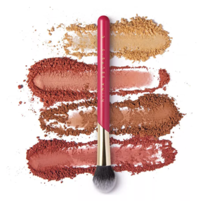 Pincel de maquilhagem vermelho e dourado sobre quatro tons distintos de sombra compacta em pó.