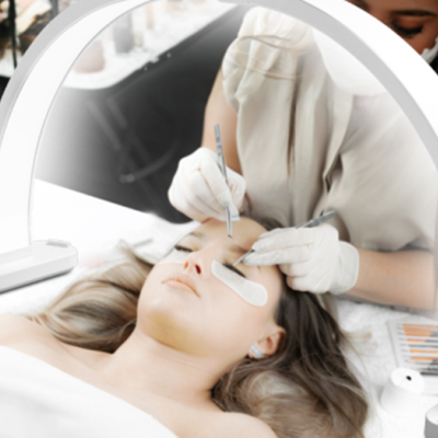 Luz de anel branca iluminando rosto feminino em procedimento de pestanas num salão