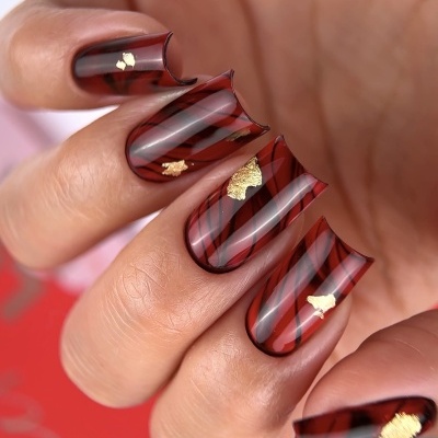 Unhas artificiais em padrão bronze e preto com folhas douradas e bordas recortadas