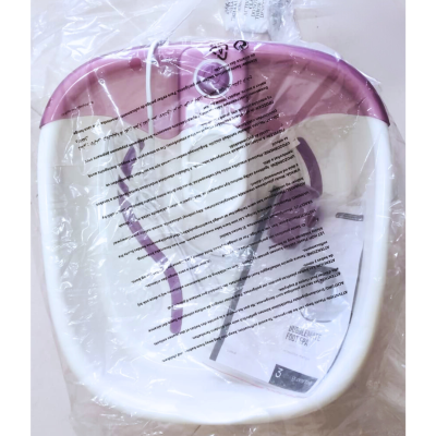 Recipiente plástico branco com borda rosa e partes roxas dentro de saco plástico transparente sobre superfície clara.