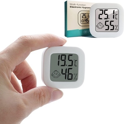 Mostrador digital branco quadrado de temperatura e humidade nas mãos