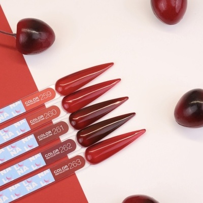 Vernizes de unhas vermelhos e cerejas sobre fundo branco e vermelho