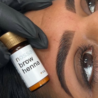 Frasco 'nossa brow henna' perto de sobrancelha bem delineada