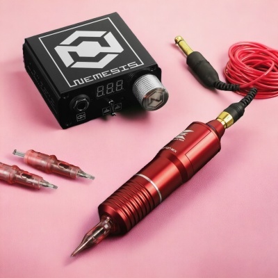 Máquina de tatuagem preta e vermelha com dois bicos adicionais sobre fundo rosa