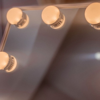 Espelho com luzes redondas acesas na moldura superior