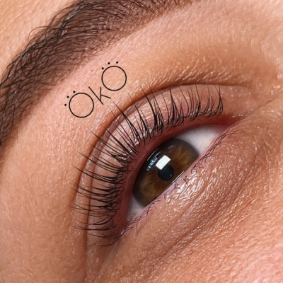 Close-up de olho castanho com pestanas longas e palavra ÖKO