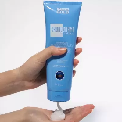 Tubo azul de crema hidratante espreme para a mão aberta