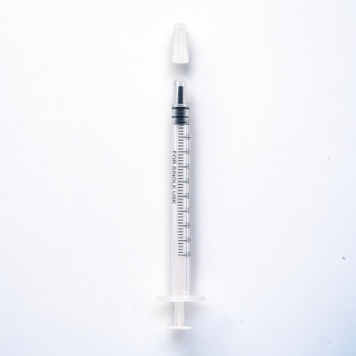 Seringa transparente com graduação e tampa branca sobre fundo branco