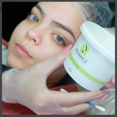 Pote branco de creme NUANCE SKIN INSIDER 150g e rosto de mulher com sobrancelhas preenchidas