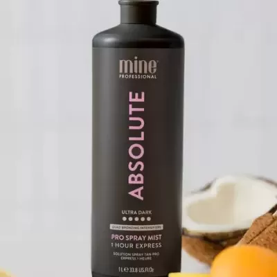 Frasco preto de produto Mine Professional Absolute Ultra Dark com laranja e coco ao fundo
