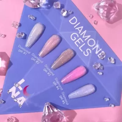 Cartão azul com amostras de gel para unhas cintilantes e cristais de acrílico num fundo rosa