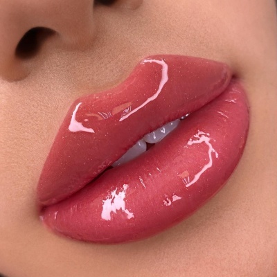 Lábios femininos com gloss labial cor-de-rosa brilhante