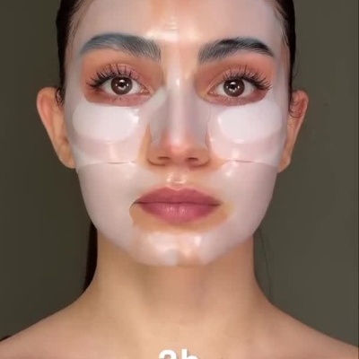 Mulher aplicando máscara facial transparente no rosto com indicação de tempo de uso em vídeo