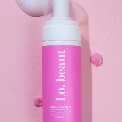 Frasco de espuma de limpeza rosa Lo.beaut sobre fundo rosa com espuma