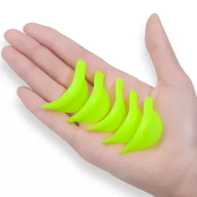 Mão segurando cinco miniaturas de bananas verdes fluorescentes em plástico