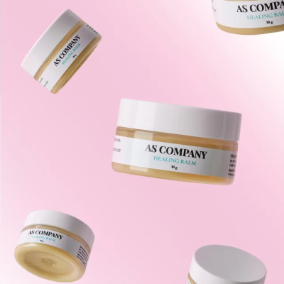 Frascos de creme AS COMPANY HEALING BALM 30 g com tampa branca sobre fundo rosa