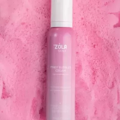 Frasco rosa de creme Zola Skin sobre espuma rosa
