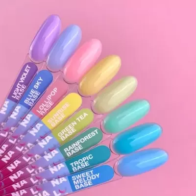 Amostras de verniz de unhas em tons pastel e azul com nomes localizadas em suportes transparentes sobre fundo rosa.