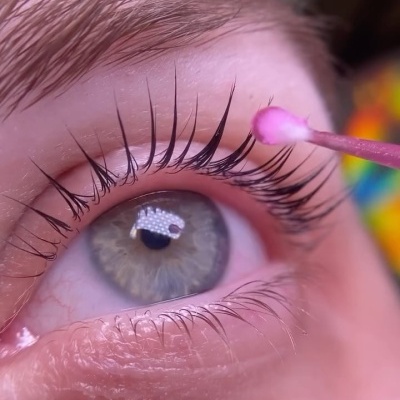 Close-up de olho com pestanas e aplicador rosa