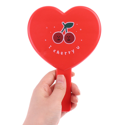Espelho de mão vermelho em forma de coração com desenho de cerejas e texto 'I cherry U'