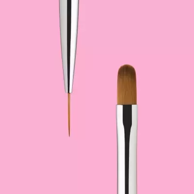 dois pincéis de maquilhagem com cabo metálico prateado em fundo rosa