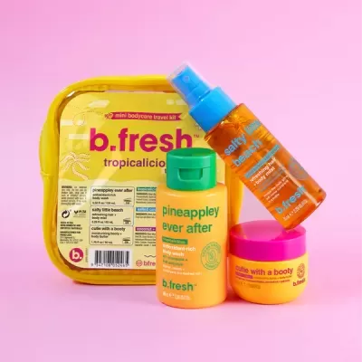 Conjunto de produtos mini b.fresh tropicalicious com gel de banho, creme corporal e spray em embalagem amarela sobre fundo rosa