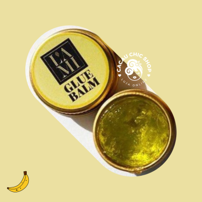 Frasco redondo de bálsamo verde com tampa amarela e texto.