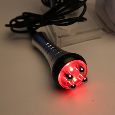 Aparelho elétrico portátil com luz LED vermelha e esferas metálicas na ponta