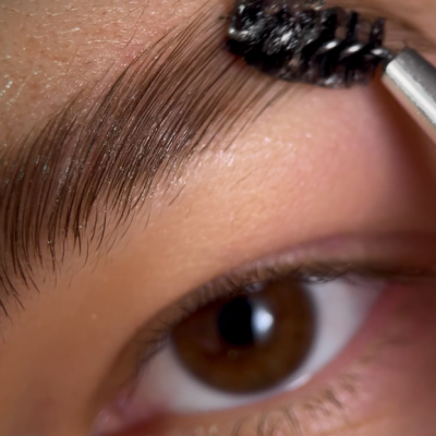 Escova de sobrancelhas a pentear sobrancelha castanha perto do olho castanho