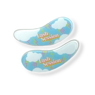 Dois pads para olhos azul claro com padrão de nuvens, raios e texto 'Lash Session'