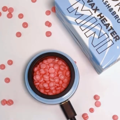 Mini aquecedor de cera com pastilhas cor-de-rosa e embalagem azul