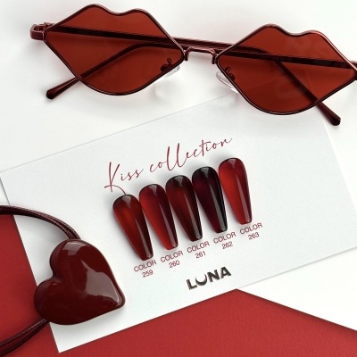 Óculos vermelhos em forma de lábios, amostra de unhas postiças vermelhas e pulseira de coração vermelho