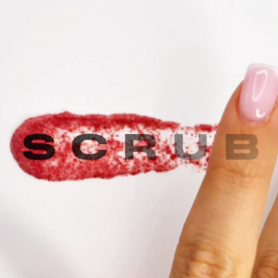 Dedo com produto esfoliante vermelho e palavra SCRUB