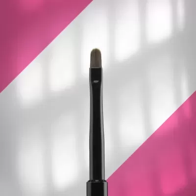 Pincel de maquilhagem com cabo preto e cerdas castanhas em fundo branco e rosa